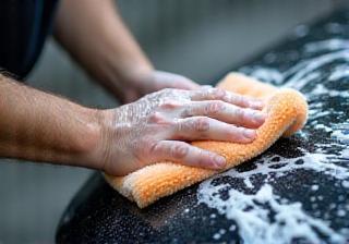 Technician carefully washing a car